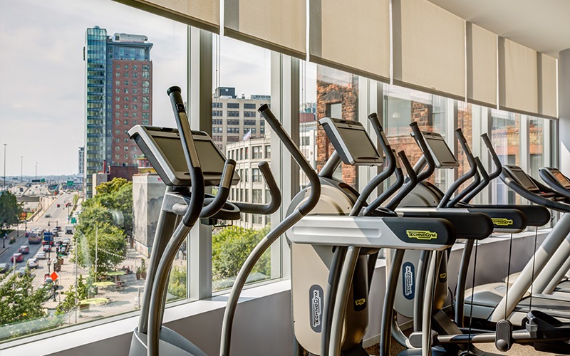 Fitness center with ellipticals looking out into a city view