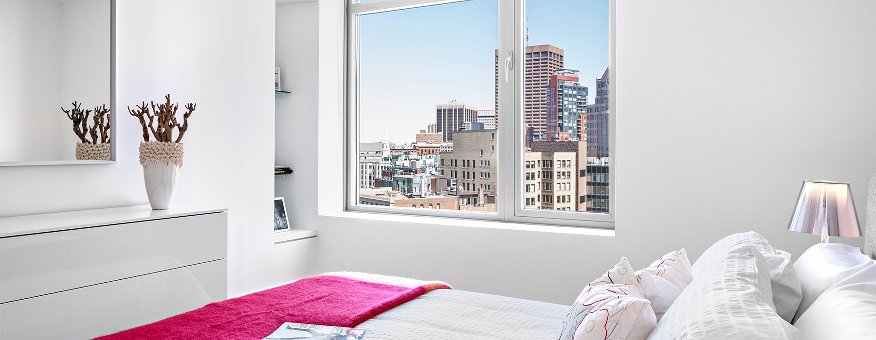 Bedroom with view of cityscape outside window