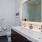 Spacious bathroom with double sink, walk-in shower, and backlit mirror